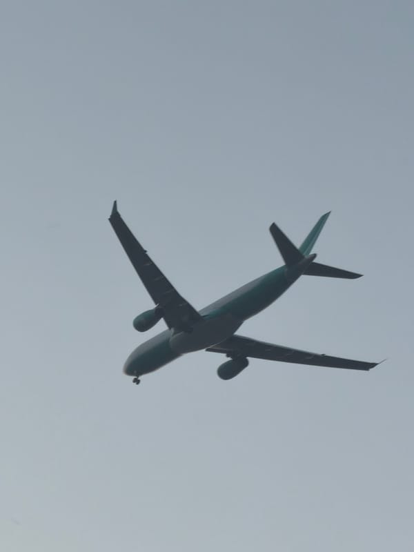 Planes cross a Delhi sunset sky from a rooftop viewpoint