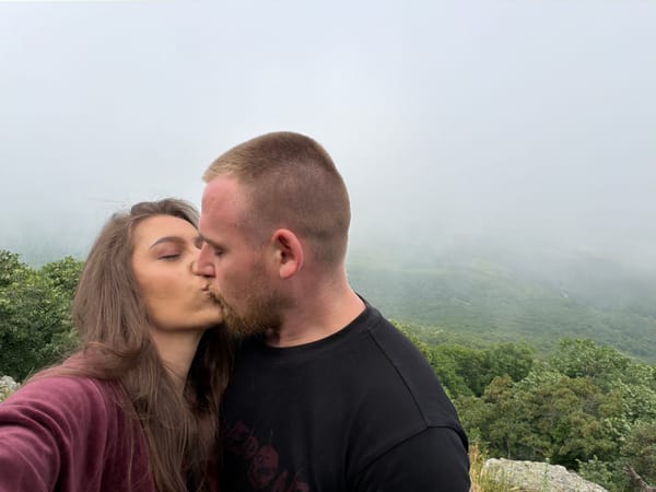 Couple shares intimate moments at foggy mountain viewpoint