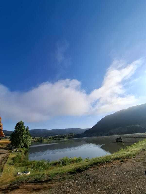 Calm reservoir under a cloud-scattered sky in rural Bulgaria