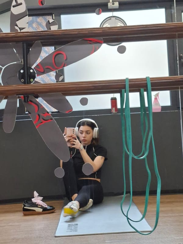 Woman records selfie on yoga mat with headphones