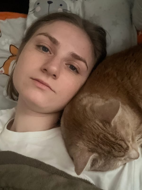 Woman and orange cat share quiet moment in Novosibirsk