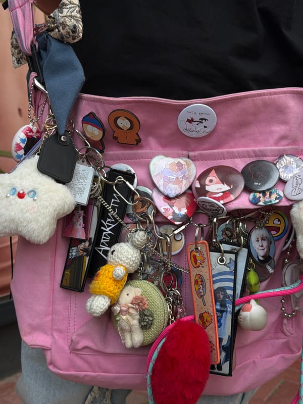 Decorated pink backpack spotted with anime pins in Budva