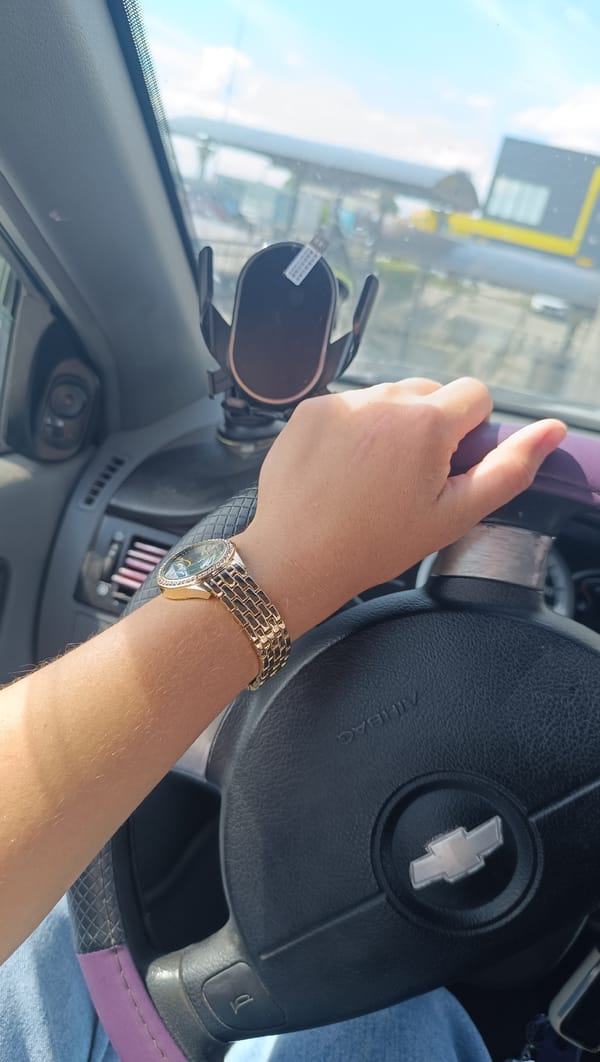 Inside a car in Chaikovsky, gold watch on the wheel