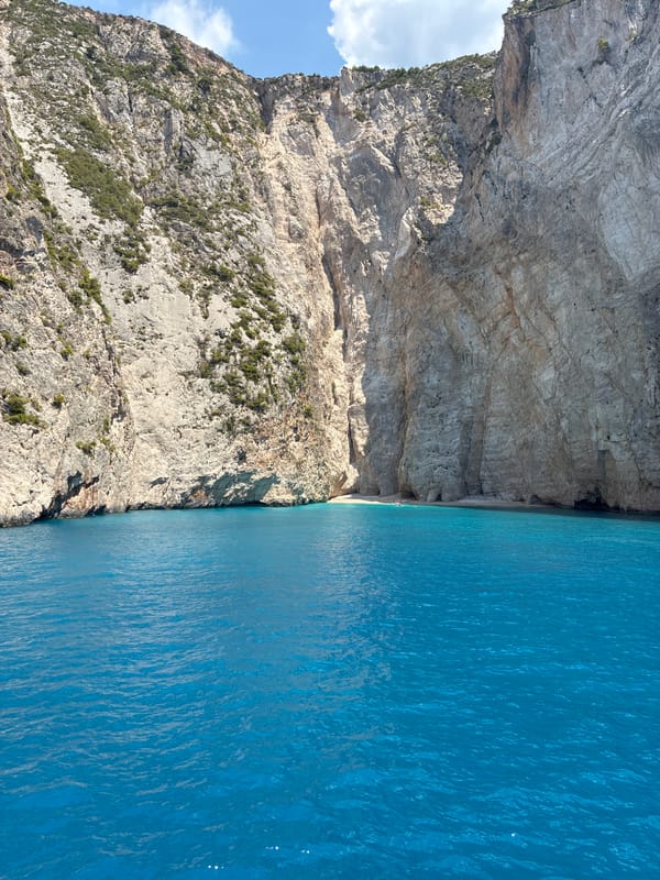 Rocky cliffs rise from turquoise water off the Greek coast