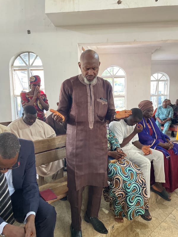 Worship gathering in Jos, Nigeria, mid-prayer moment.