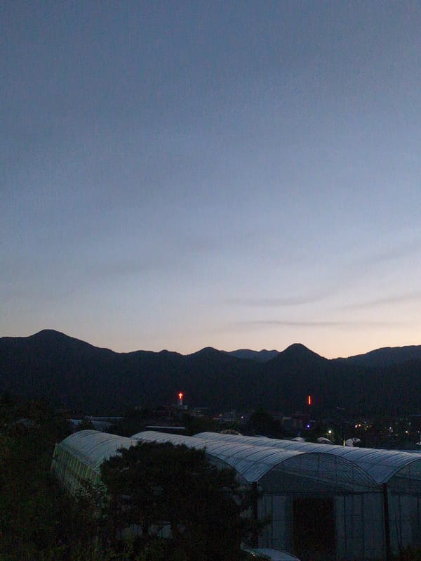 Twilight scene with mountains and modern architecture captured in Iwon