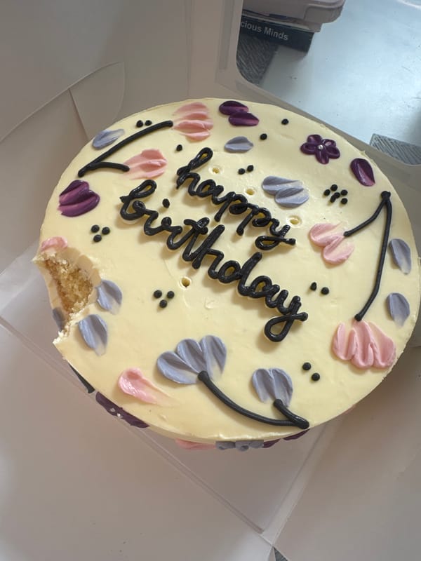Decorated birthday cake with yellow frosting observed in box