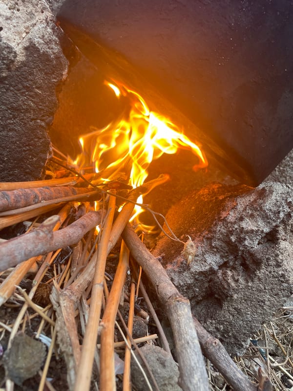Person tends makeshift fire hearth in Jos, Nigeria