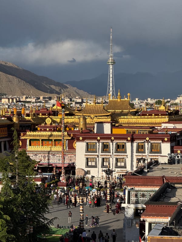 Pilgrims carry prayer wheels near Potala Palace in Lhasa