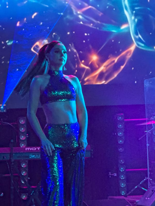 Live stage performance in Georgia, sparkly green outfits and cosmic visuals