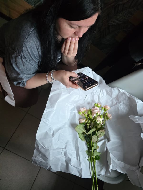 Woman in Gray Sweatshirt, Pink Roses Documented Indoors