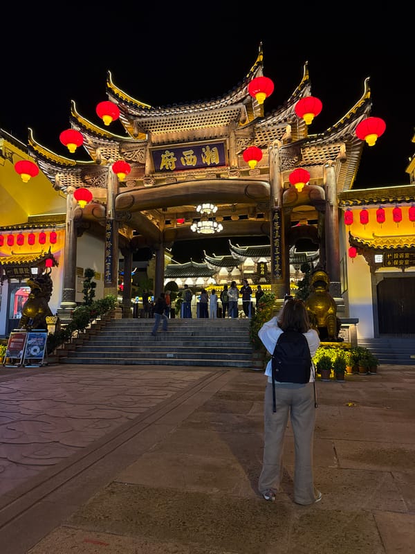 Night crowds gather at illuminated traditional architecture in Wulingyuan