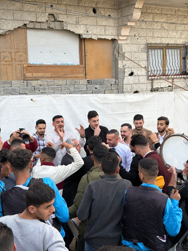 Street celebration with dancing, drumming near damaged Gaza building
