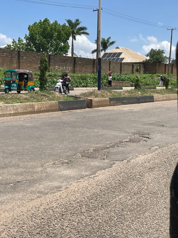 Street-level ride through Bukuru, passing shops and roadside activity