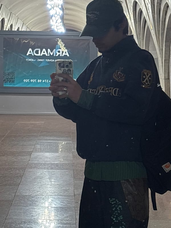 Person photographs advertising agency billboard indoors in Yerevan