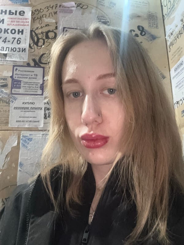 Woman takes selfies against advertisement wall in Kuleshovka