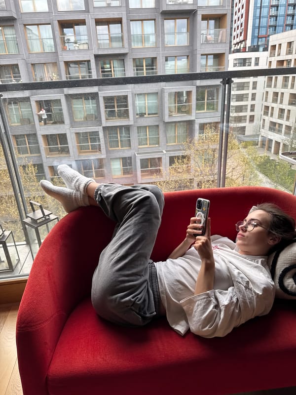 Person relaxes with phone by window in Warsaw