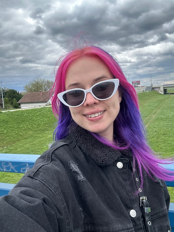 Colorful-haired person poses in Zagreb field setting