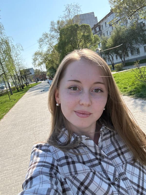 Woman films selfies in urban park amid pigeons, street activity