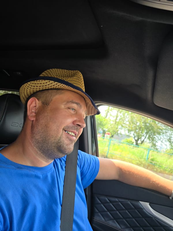 Straw hat, blue tee, parked car — Krasnoyarsk moment