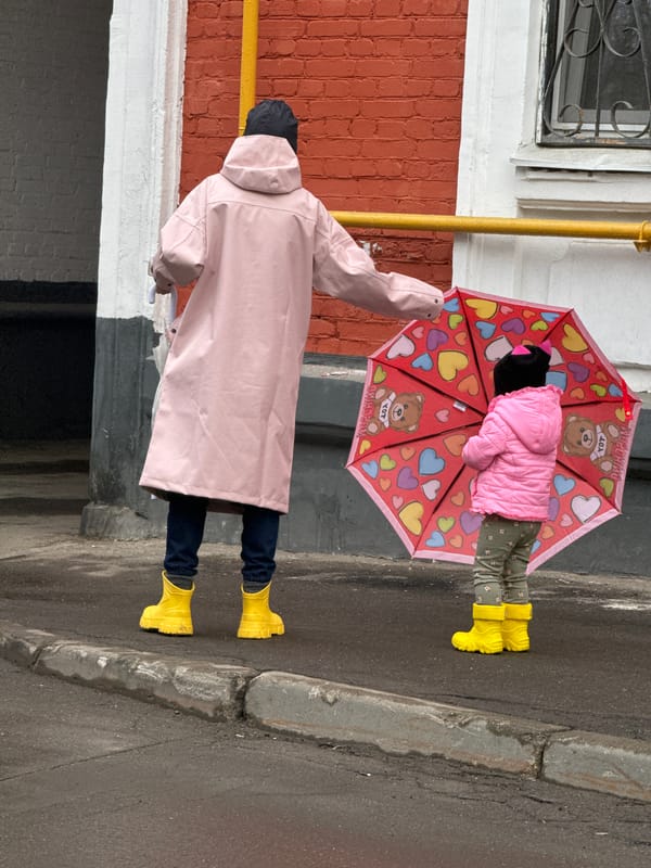 Children in colorful rain gear walk Moscow sidewalks
