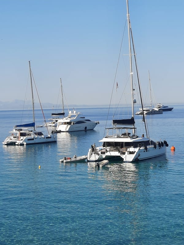 Yachts anchored in the blue waters of Platys Gialos, Greece