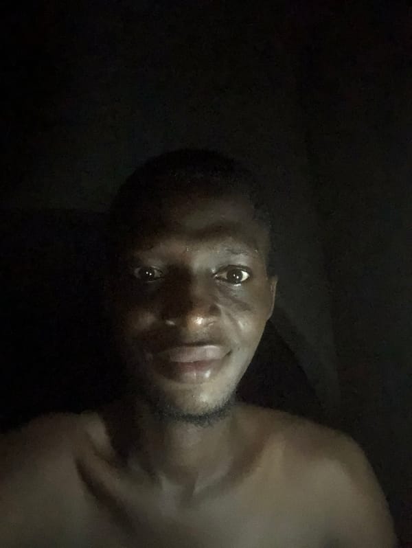 Rotated portrait of unidentified young man captured in dim lighting