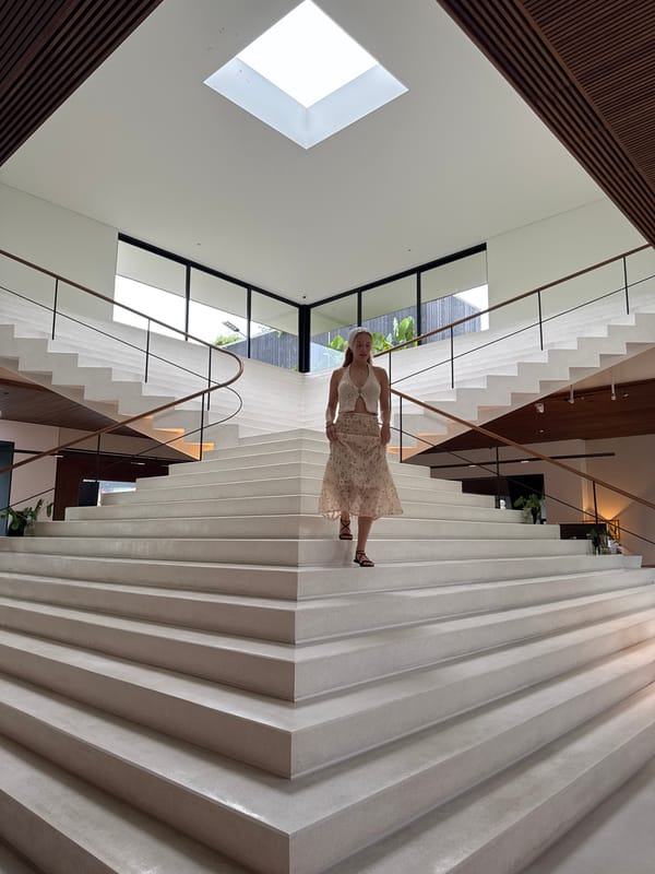 Woman walks modern split staircase in Si Sunthon building