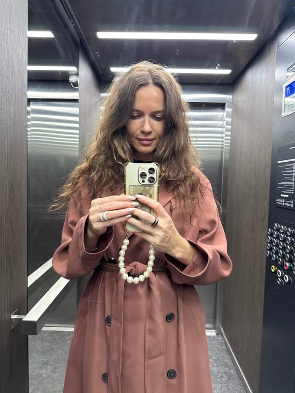 Elevator selfie in Dolgoprudny, pink trench coat and pearls.