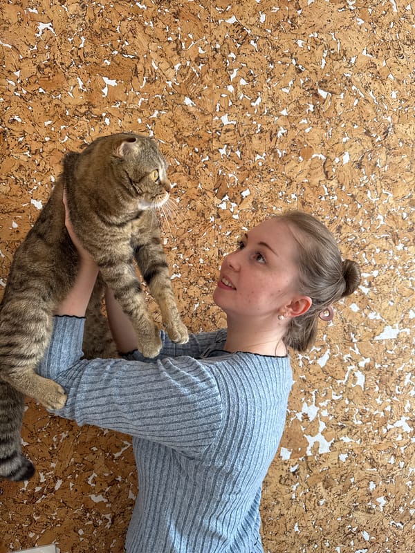 Woman shares tender moment with tabby cat on cork floor