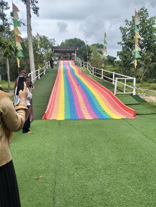 Rainbow slide installed on grassy hill in Lhokseumawe