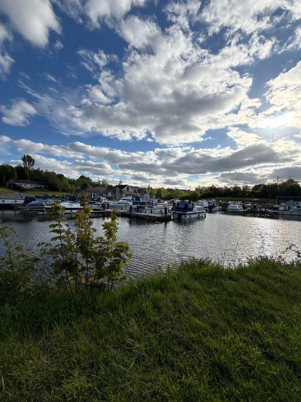 Cyclist adjusts fallen bicycle near canal with moored boats