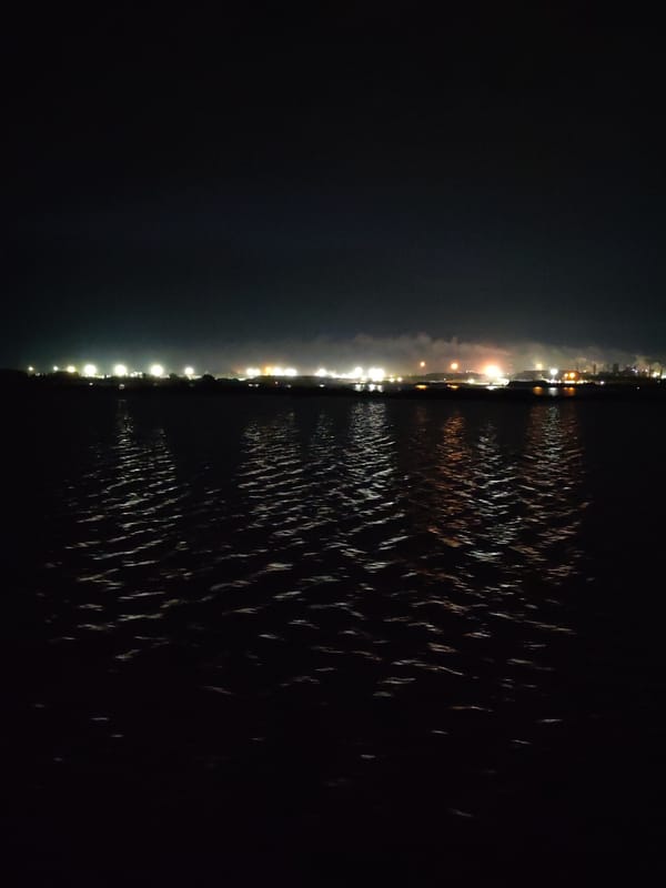 Nighttime industrial waterfront lights captured across 48-minute span