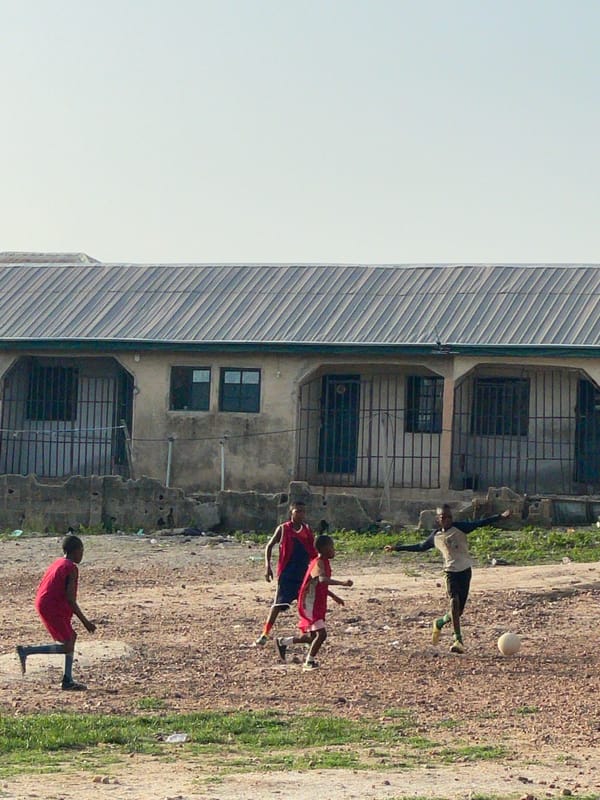 Children play soccer on sandy field in Lokoja Nigeria