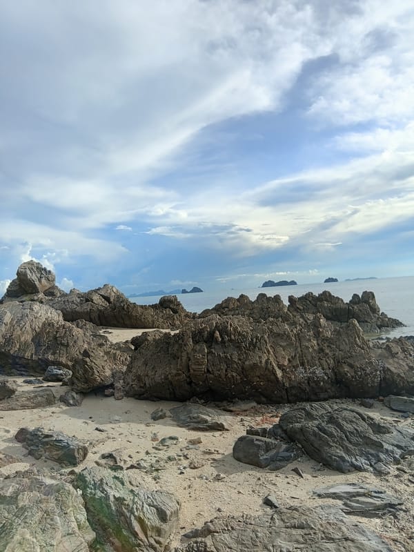 Temple blessings and rocky coastline at Baan Taling Ngam