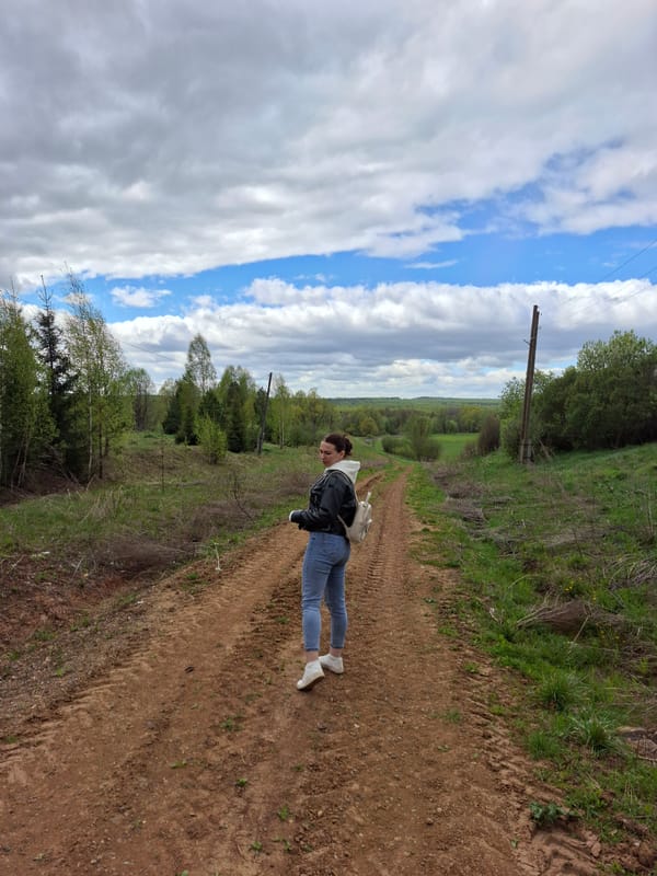 Woman walks dirt road in rural Russian village