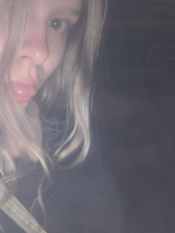 Woman takes selfie in residential Sinyavino at dusk