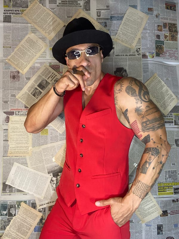 Dapper figure with cigar poses before newspaper-covered wall in Pleven