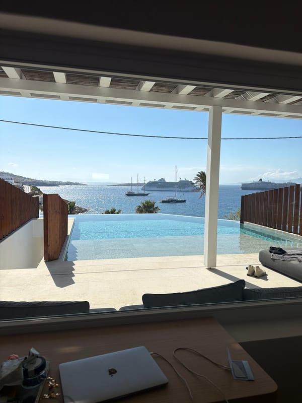 Poolside relaxation captured at Mykonos infinity pool overlooking harbor