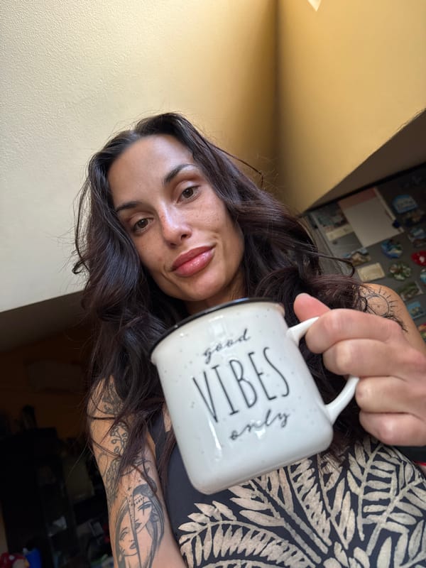 Woman with tattoos holds inspirational mug in early morning Bulgaria