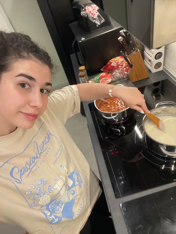 Woman takes kitchen selfies while feeding cucumber to poodle