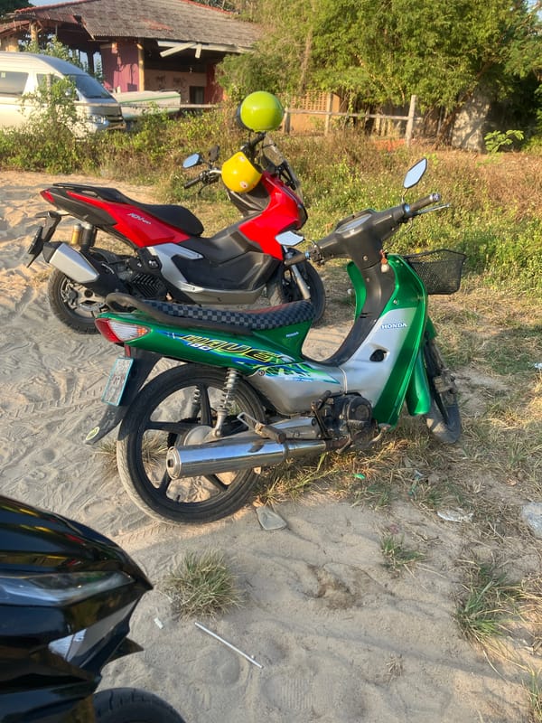Motorcycles parked at sandy Choeng Mon beach area, Thailand