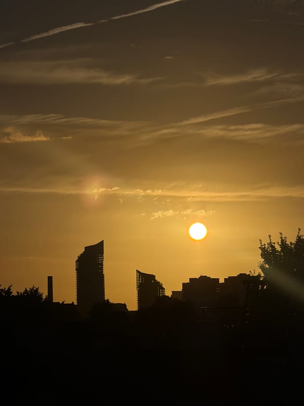 London skyline silhouetted against a warm hazy sunset