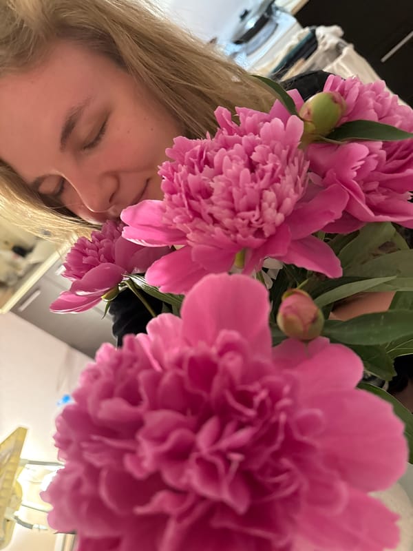 Woman enjoys peonies and wine in Vladimir indoor gathering