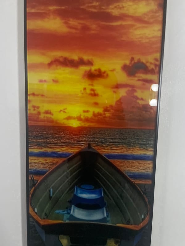 Four landscape and seascape artworks displayed on walls in Abuja