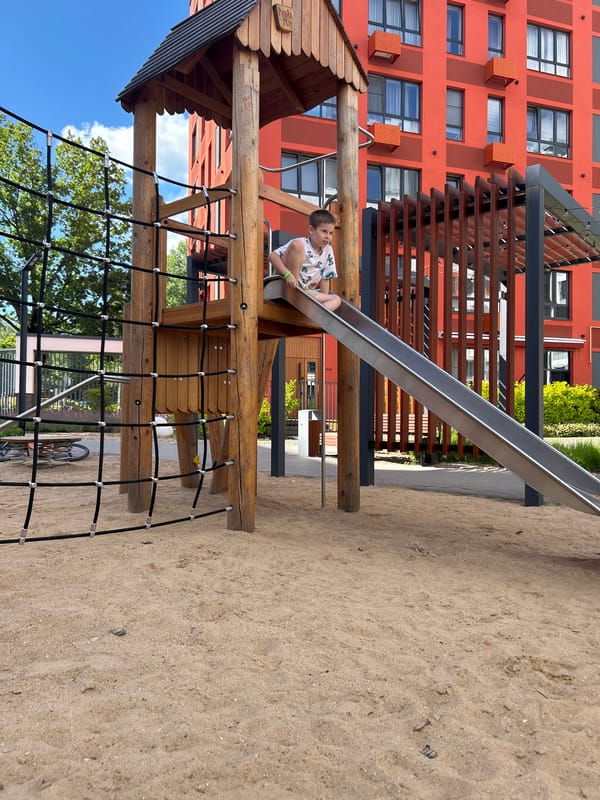 Sunny afternoon at a Kaluga playground, kids and sandbox in full swing.