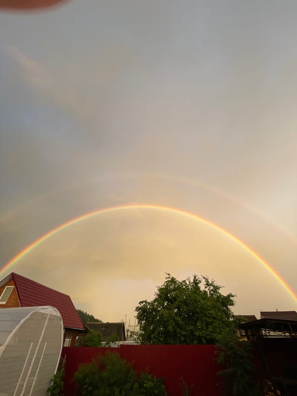 Double rainbow over a rural neighborhood at golden hour
