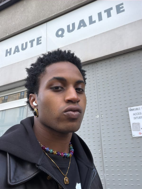Individual photographed wearing hooded jacket and jewelry in Paris