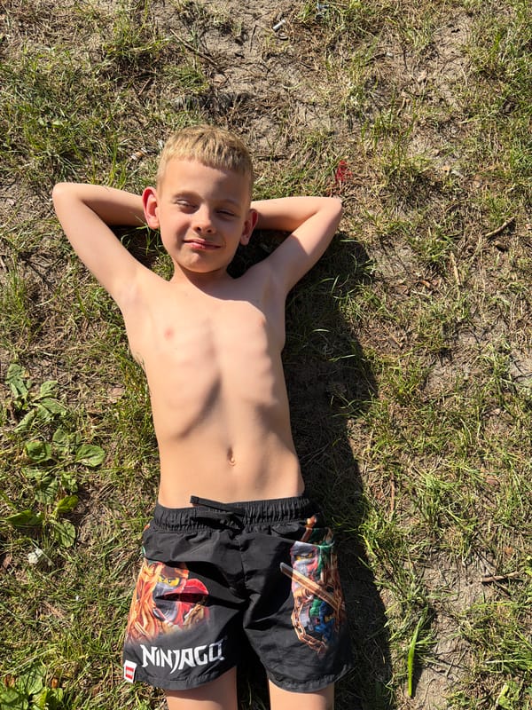Sunny lake day with kids swimming and playing in pine forest