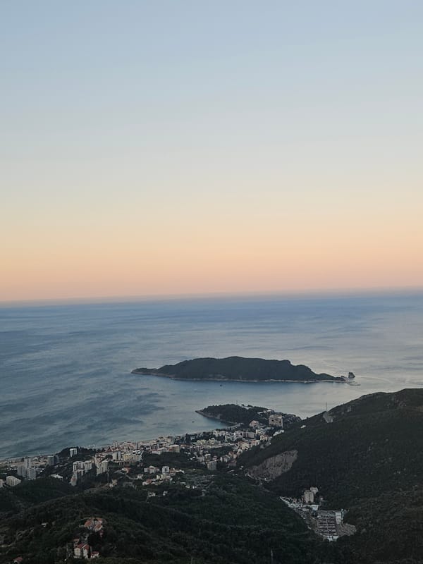 Budva's coastline at dusk, layered sky and sea.